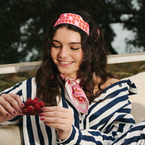 Femme portant un foulard et un ruban en soie rose rouge et blanc