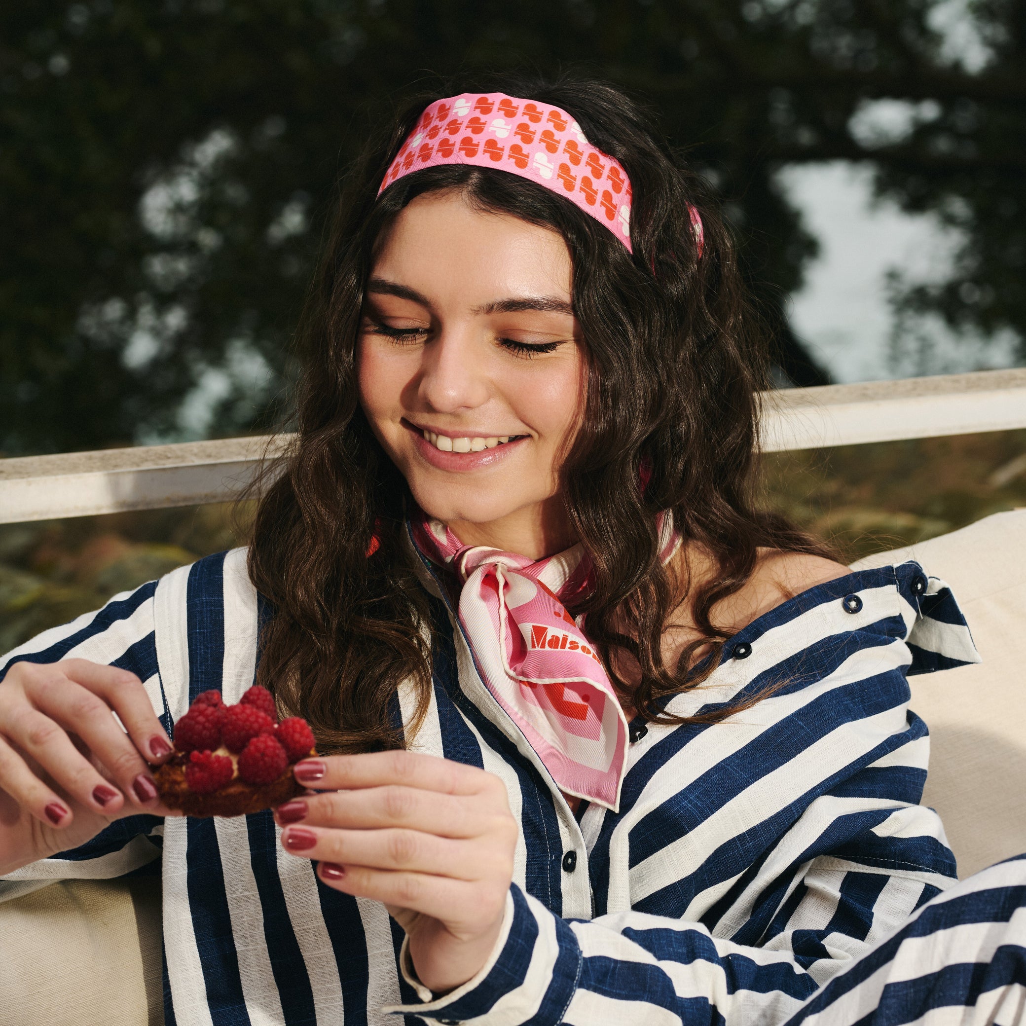 Femme portant un foulard et un ruban en soie rose rouge et blanc