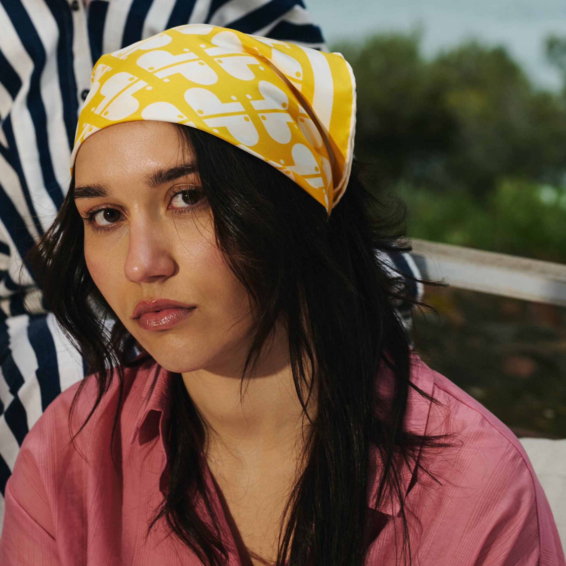 Femme portant sur la tête un foulard en soie imprimé jaune et blanc