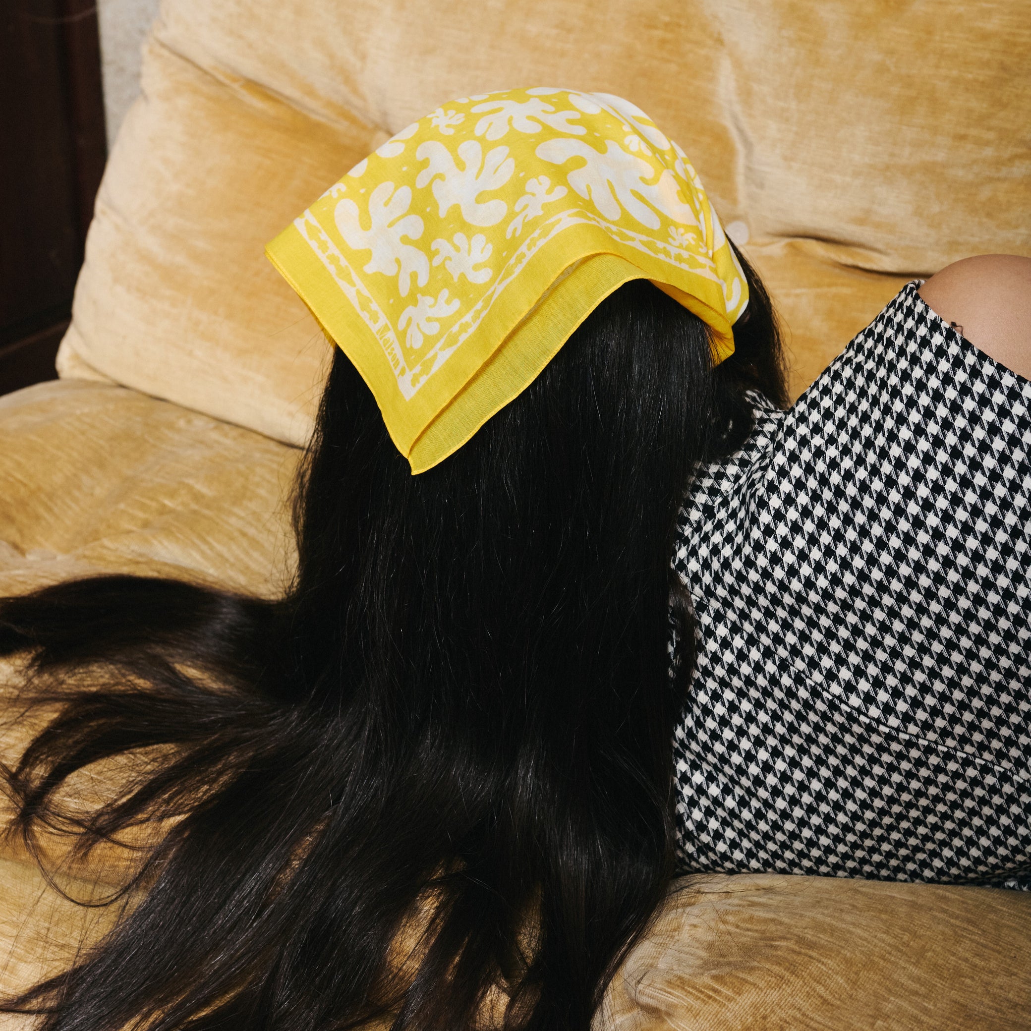 Femme portant sur la tête un foulard en coton jaune et blanc