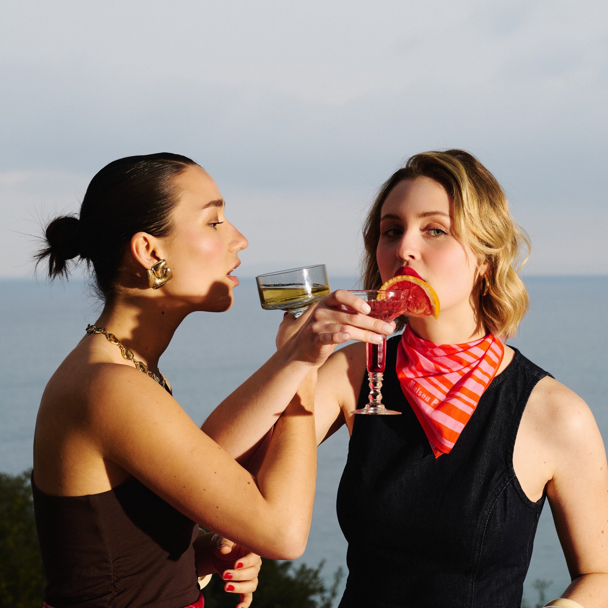 Femme portant autour du cou un foulard en coton rose et rouge