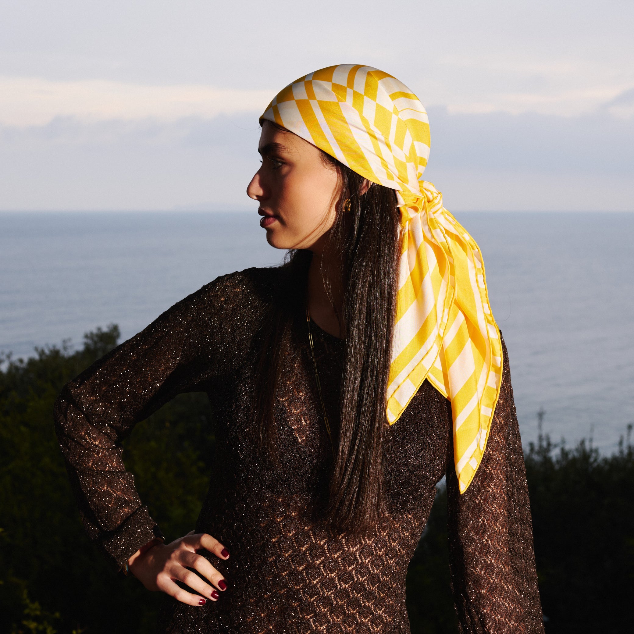 Femme portant sur la tête un foulard en soie imprimé jaune et blanc