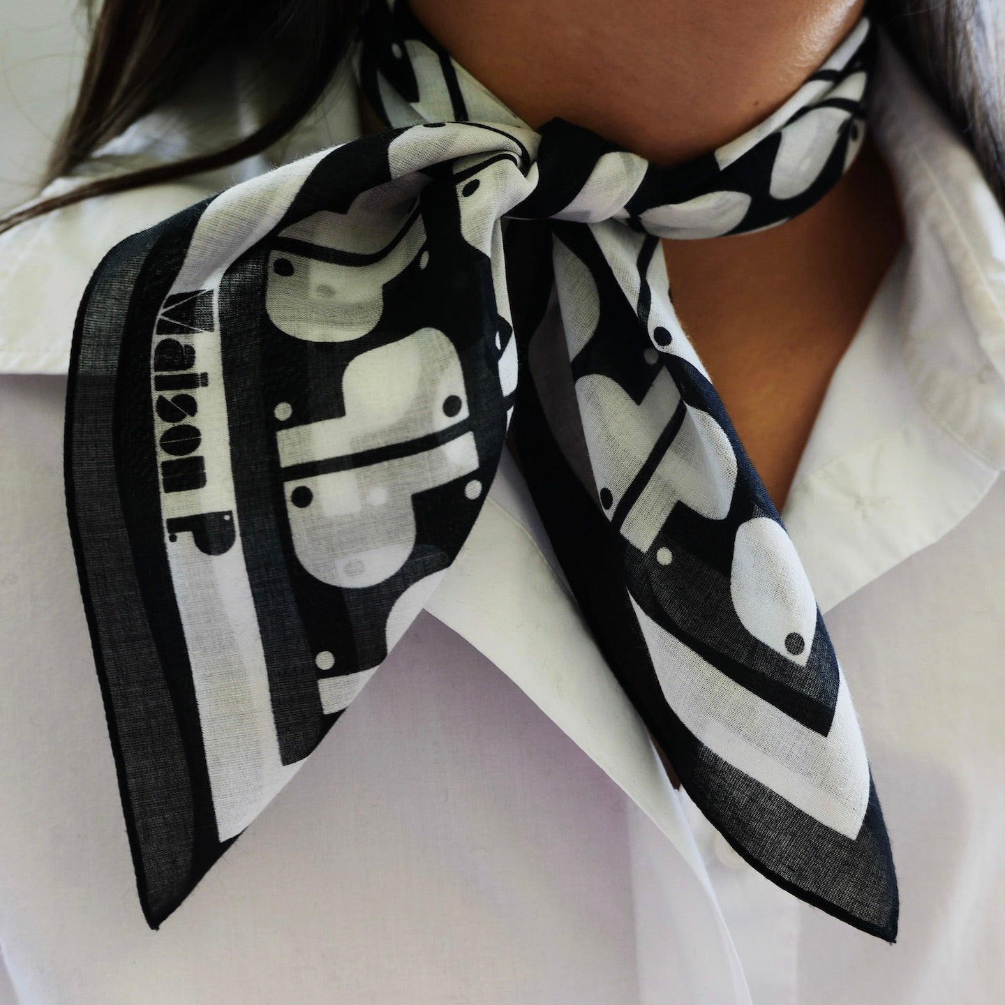 Femme portant autour du cou un foulard en coton imprimé noir et blanc 50 x 50 cm